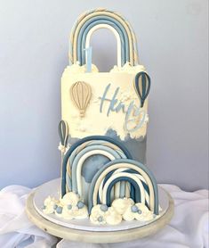 a white and blue cake with hot air balloons in the shape of a lock on top