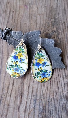 These delightful happy flower statement earrings are made with vintage tin. First it was sawed out from a vintage tin box and then it was gently hammered into shape. After that, it is sanded around so that it can be soldered. The backsides are cream colored. The tin shows marks of its age, but this does not take away any of its beauty. The ear wires are sterling silver. These are big! A total length of 2 7/8'' (7.5 cm) but very comfortable of weight. Due to the vintage tin a one of a kind. All metal is nickel and lead free, the ear wires are sterling silver (925). More vintage tin jewelry available in the shop: https://www.etsy.com/shop/StaroftheEast?ref=seller-platform-mcnav&search_query=tin Two shipping options: Registered airmail takes 15 - 30 days on average,it is cheap and safe but sl Vintage Blue Flower Drop Earrings, Blue Vintage Flower Drop Earrings, Vintage Blue Flower Earrings, Vintage Blue Flower Earrings Nickel Free, Vintage Blue Flower Earrings, Nickel-free, Blue Vintage Flower Earrings Nickel-free, Vintage Hand Painted Drop Earrings, Hand Painted Vintage Drop Earrings, Vintage Blue Handmade Flower Earrings