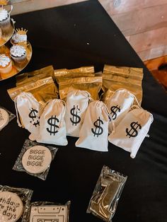 bags of money are sitting on a table with cupcakes