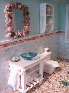 a bathroom with shells on the floor and a sink in the corner, along with a toilet