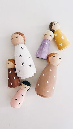 three wooden peg dolls sitting next to each other