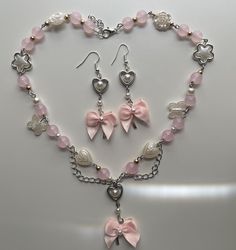 A pink pearlescent necklace with pink glass beads, and white pearls with a bow pendant for necklace and earring. Coquette Necklace, Coquette Jewelry, Collar Rosa, Pink Coquette, Jewelry Accessories Ideas, Jewellery Sets, Pink Jewelry, Pretty Necklaces, Bow Earrings