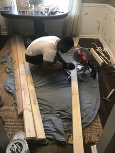 a man is working on some wood planks