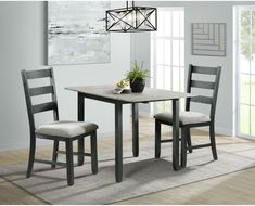 a dining room table with two chairs and a potted plant