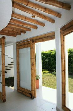 the inside of a house with wooden beams and glass doors that lead to an outside patio