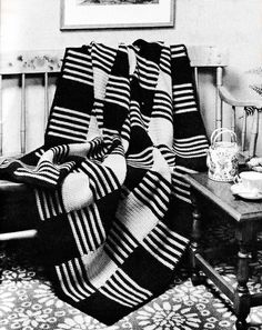 a black and white photo of a living room with a striped blanket on the couch