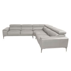 a white leather sectional sofa sitting on top of a wooden floor