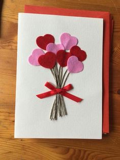 valentine's day card with red and pink felt hearts tied to the front of it