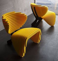 two yellow chairs sitting next to each other in front of a window on top of a black floor