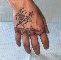 a person's hand with tattoos on it and stars in the middle of their palm