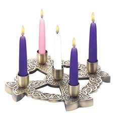 six lit candles are arranged in a star shaped candle holder with intricate designs on the sides