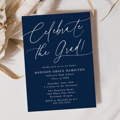 a blue and white wedding card with the words celebrate the god on it next to some feathers