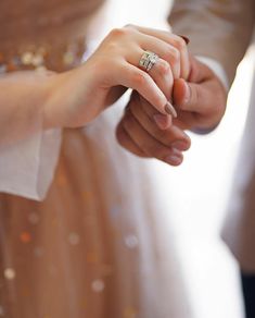 the bride and groom hold hands as they stand close to each other in their wedding dress