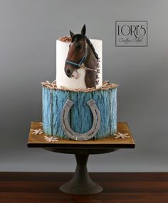 a cake with a horse head on top and a rope around the base that is decorated like a horseshoe