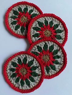 three crocheted coasters with green and red designs