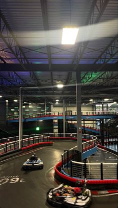 two go - karts racing in an indoor race track