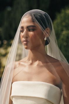 a woman wearing a wedding veil and dress