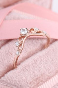 a close up of a ring on top of a pink blanket with diamonds in it