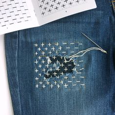 a pair of jeans that have been sewn together and are sitting on a desk