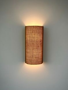 a wall mounted light with a fabric shade on it's back end and side