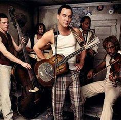 a group of men standing next to each other holding guitars