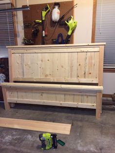 a wooden bench sitting in a garage next to tools