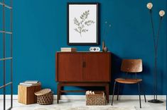 a living room with blue walls and wooden furniture in the corner, along with two wicker baskets on the floor