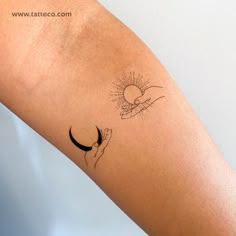 a woman's arm with a tattoo on it and the sun in the background