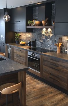 a kitchen with wooden floors and black cabinets, an island countertop and two pendant lights