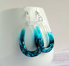 blue and white hoop earrings on top of a cup