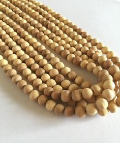 "Wood Beads 8 mm 545 beads (Unpolished Natural). These beads can be used to make your own Necklaces, Jewellery and Japa malas.  Since the wood beads are hand carved, they might not be perfectly uniform, and may have some imperfections related to wood. --> Price is for 5 strands (545 beads in total) --> Bead size 7-8 mm approximately --> The bead size is measured non- hole side Check other beads here - https://etsy.me/2xBmAsK Visit our shop here- https://etsy.me/2IgCTfg -------------------------- Wooden Beads For Jewelry Making, Natural Beaded Necklaces With Round Beads, Natural Round Beaded Necklaces, Wooden Round Beads For Jewelry Making, Round Wooden Beads For Jewelry Making, Buddhist Rosary, Sandalwood Mala, Beads Mala, Meditation Beads