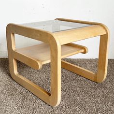 a wooden table with glass top on carpeted floor