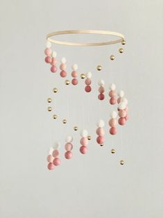 a pink and white mobile hanging from a wall