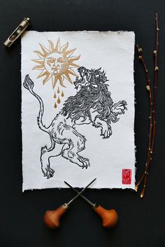 a piece of paper with a drawing of a lion on it next to some scissors