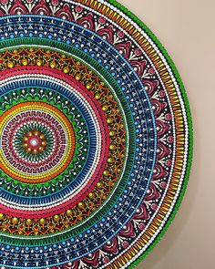 a colorful circular artwork hanging on the wall