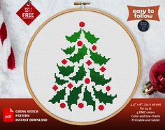 a cross stitch christmas tree with red berries