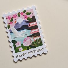 a close up of a stamp with a bird on it and flowers in the background