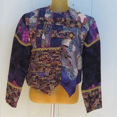 Hand Sewn Custom Quilted Jacket In Shades Of Purple, Cream, Tan, Soft Green And Blue With Gold Brocade Trim. Asian Themed And Contemporary Fabrics And Design. Feels Like Cotton. Very Unique And Well-Made Cropped Evening Jacket Can Be Worn Open Or Closed. I'm Guessing The Size To Be Medium Or Large. Armpit To Armpit: 19 1/2" Length From Shoulder: 19 1/2" Sleeve: 23" Measurements Are Approximate. Purple Patchwork Long Sleeve Top, Purple Long Sleeve Patchwork Top, Purple Long Sleeve Top With Patchwork, Fitted Bohemian Purple Outerwear, Fitted Purple Bohemian Outerwear, Evening Jacket, Gold Brocade, Contemporary Fabric, Evening Jackets