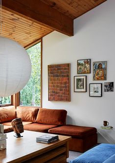 a living room filled with furniture and a large white light fixture hanging from the ceiling