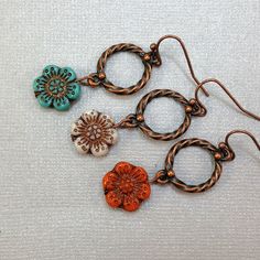 Earrings featuring beautiful colored Czech glass flower beads dangling from antique copper rings.  Choose your flower color below: Red-Orange, White, or Turquoise with copper inlays. Fun and festive handmade jewelry.  Flower beads have beautifully detailed copper inlays.  Dress these flower earrings up or wear them casually. Artisan glass beads produced in small quantities in the Czech Republic Hypoallergenic ear wires (nickel and lead free). French ear wires come with silicone stoppers. Choose Handmade Copper Flower Earrings, Adjustable Copper Flower Earrings, Nickel-free Flower Shaped Copper Jewelry, Nickel-free Flower-shaped Copper Jewelry, Nickel-free Copper Flower Jewelry, Bohemian Copper Flower Jewelry, Bohemian Flower Copper Jewelry, Bohemian Flower-shaped Copper Jewelry, Nickel-free Copper Flower Drop Earrings