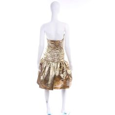 For Sale on 1stDibs - This is a fun vintage textured gold lurex strapless cocktail or party dress from the 1980's. The drop waist bodice is fully ruched and the skirt is lined Glamorous Gold Strapless Evening Dress, Vintage Summer Party Corset Dress, Gold Strapless Dress With Sweetheart Neckline For Party, Gold Strapless Dress For Evening, Glamorous Gold Fitted Strapless Dress, Glamorous Cocktail Strapless Dress With Pleated Bodice, Elegant Gold Corset Dress For Party, Gold Cocktail Dress With Fitted Bodice, Gold Ruched Mini Dress For Formal Occasions