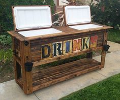 two coolers sitting on top of a wooden bench with the word drinks painted on them