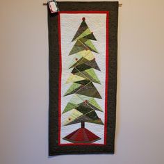 a quilted christmas tree hanging on the wall