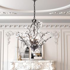 a chandelier hanging from the ceiling over a fireplace in a room with white walls