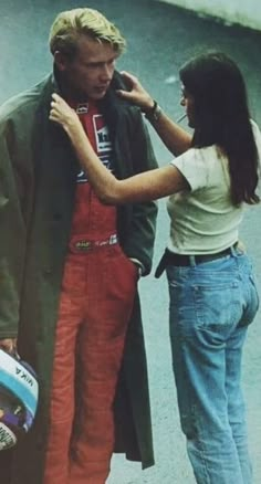 a man and woman standing next to each other in front of a skateboard ramp