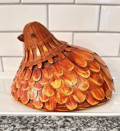 a bird shaped basket sitting on top of a white tile counter next to a tiled wall