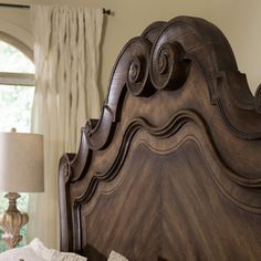 a bed with a wooden headboard and night stand