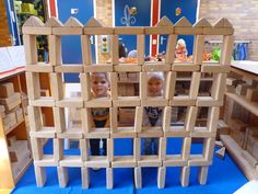 two young boys are playing with blocks in the shape of a castle on a blue carpet