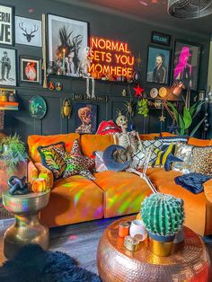 a living room filled with lots of colorful furniture and pictures on the wall above it