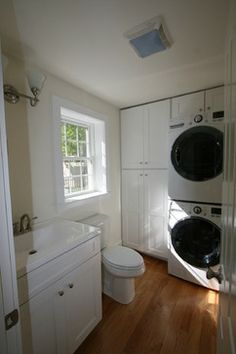 a white washer and dryer in a room with wood flooring on the wooden floor